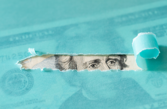 money with a green overlay ripped back