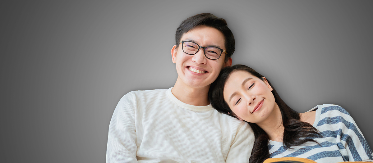Man and woman leaning against each other smiling
